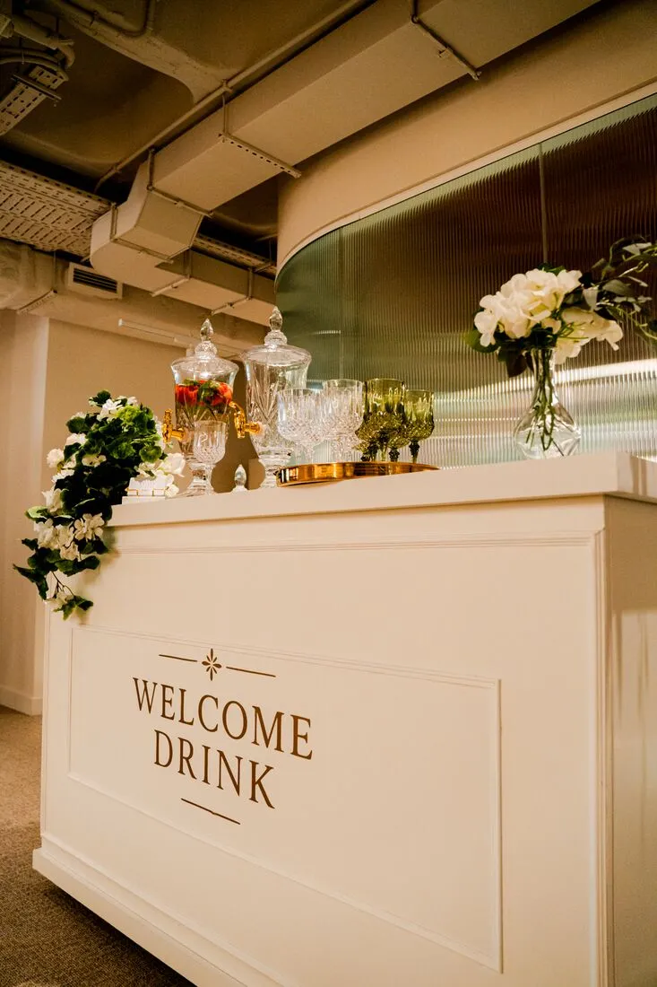 Balcão branco com a inscrição Welcome Drink
