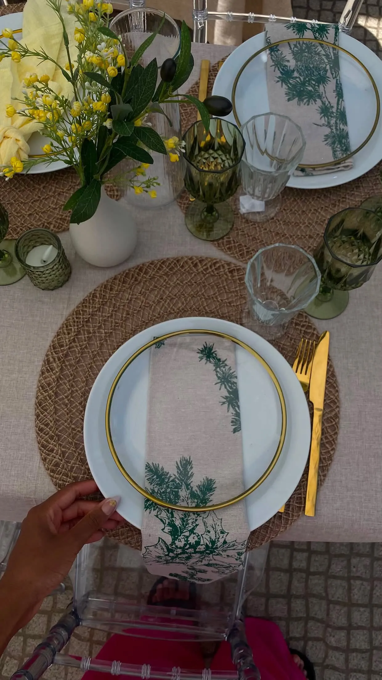 Mãos a ajustar o prato num lugar da mesa